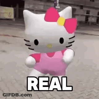 A Hello Kitty Doll Is Walking Down A Street With The Word Real Written On It . GIF