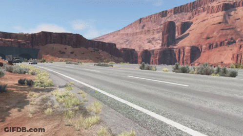 A Highway With A Tunnel In The Background And Mountains In The Background GIF