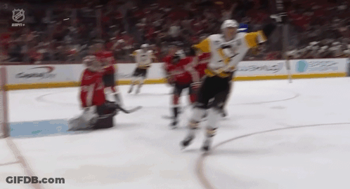 A Hockey Game Is Being Played In A Stadium With A Goalie In The Background . GIF