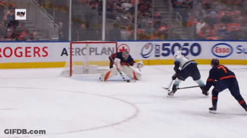 A Hockey Game Is Being Played In Front Of A Banner For Rogers And Esso GIF