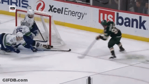 A Hockey Game Is Being Played In Front Of A Banner For Xcel Energy GIF