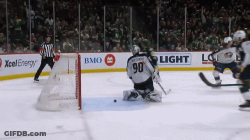 A Hockey Game Is Being Played In Front Of A Bmo Light Sign GIF
