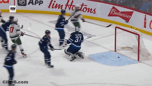 A Hockey Game Is Being Played In Front Of A Budweiser Banner GIF