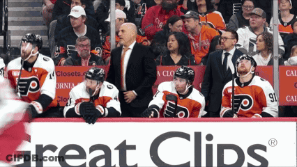 A Hockey Game Is Being Played In Front Of A Great Clips Sign GIF