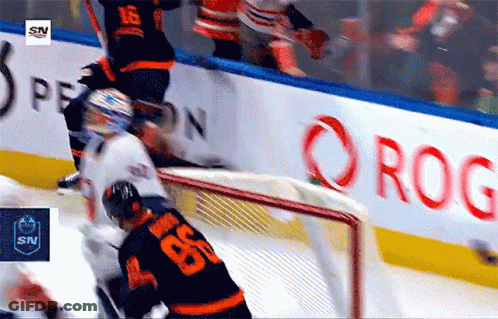 A Hockey Game Is Being Played In Front Of A Sign That Says Rog GIF