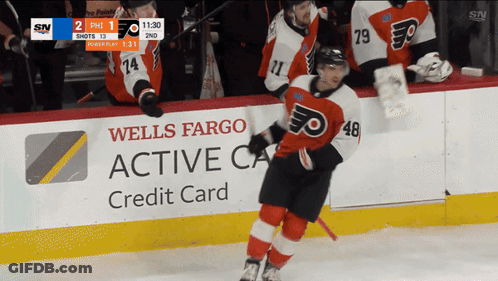 A Hockey Game Is Being Played In Front Of A Wells Fargo Credit Card Advertisement GIF