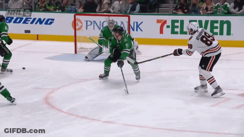 A Hockey Game Is Being Played In Front Of An Ad For 7 Eleven GIF
