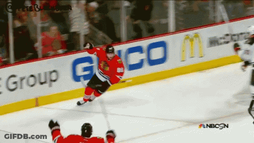 A Hockey Game Is Being Played In Front Of An Ad For Geico GIF