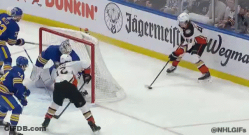 A Hockey Game Is Being Played In Front Of An Ad For Jagermeiffe GIF