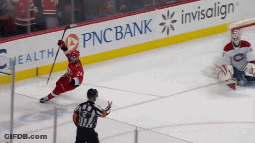 A Hockey Game Is Being Played In Front Of An Ad For Pnc Bank GIF