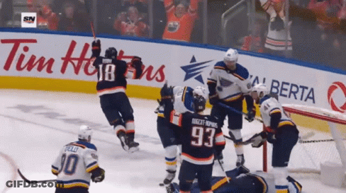A Hockey Game Is Being Played In Front Of An Ad For Tim Hortons GIF