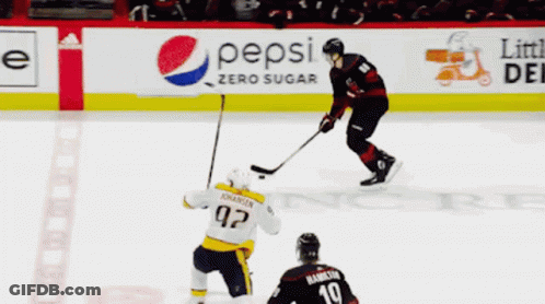 A Hockey Game Is Being Played In Front Of An Advertisement For Geico And Verizon GIF