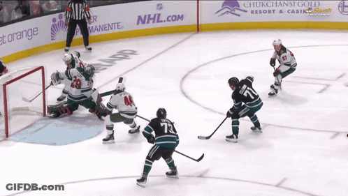 A Hockey Game Is Being Played In Front Of An Nhl.com Ad GIF