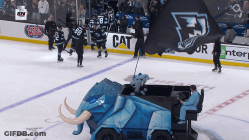 A Hockey Game Is Being Played On A Rink With A Banner That Says Cat On It GIF