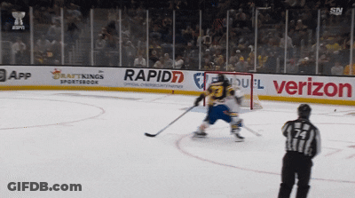 A Hockey Game Is Being Played On A Rink With Advertisements For Rapid7 And Verizon GIF