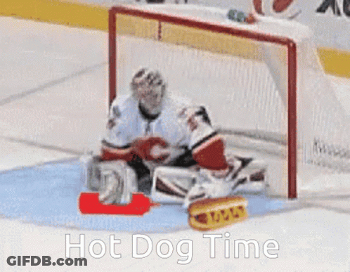 A Hockey Goalie Is Laying On The Ice With A Hot Dog In Front Of Him And The Words Hot Dog Time Below Him GIF