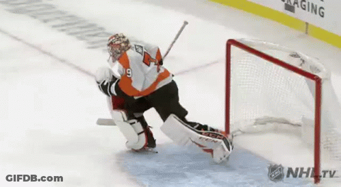 A Hockey Goalie Is Making A Save On A Goal During A Game . GIF