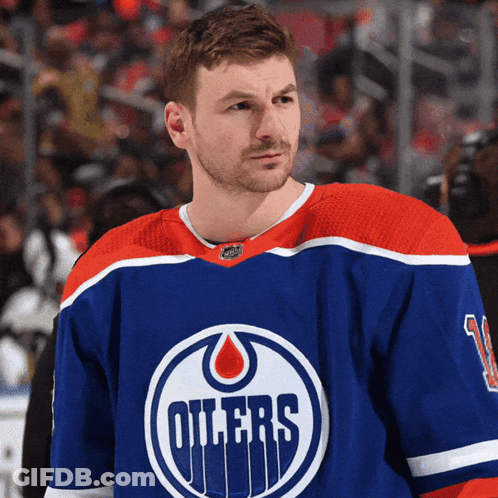 A Hockey Player For The Oilers Stands On The Ice In Front Of A Crowd GIF