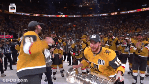 A Hockey Player Holding A Trophy With The Number 11 On His Jersey GIF