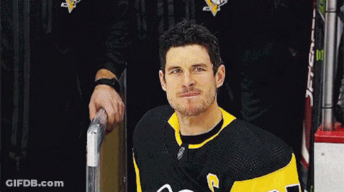 A Hockey Player In A Black And Yellow Jersey With The Letter G On The Front GIF