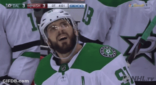 A Hockey Player In A Green And White Jersey With The Number 9 On It GIF