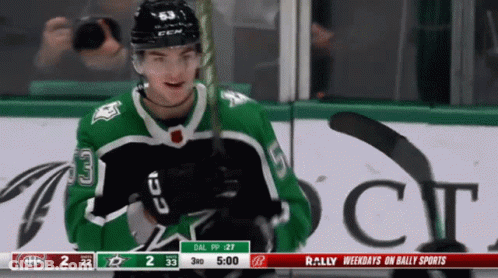 A Hockey Player In A Green Jersey With The Number 33 On The Front GIF