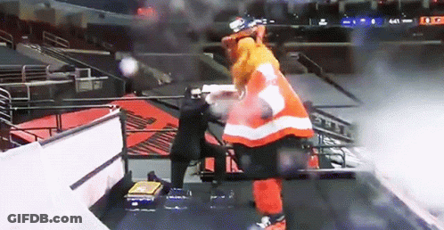A Hockey Player In An Orange And White Uniform Stands On A Staircase GIF