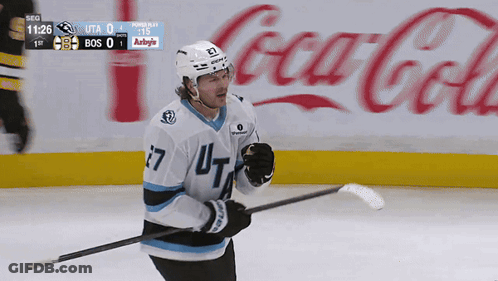 A Hockey Player In Front Of A Coca Cola Ad GIF