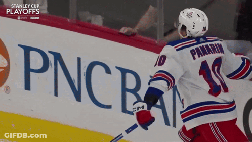 A Hockey Player In Front Of A Pncba Sign GIF