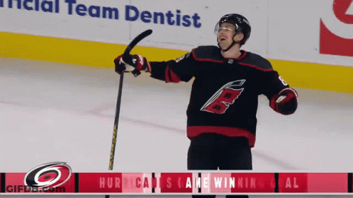 A Hockey Player Is Holding A Hockey Stick In Front Of An Ad For The Team Dentist GIF