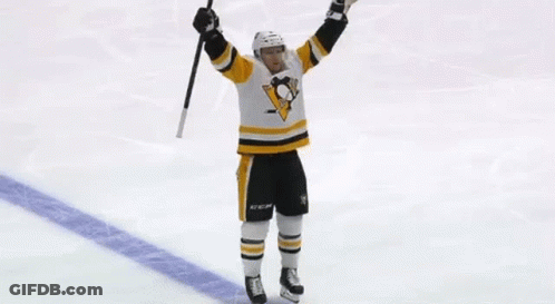 A Hockey Player Is Holding A Hockey Stick In His Hand . GIF
