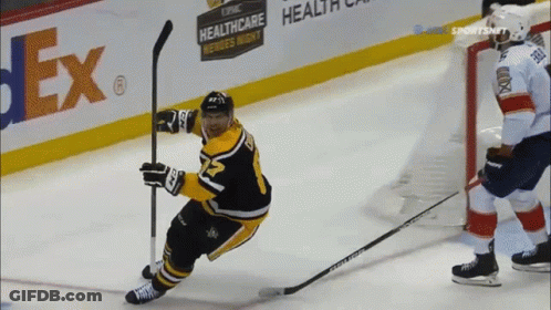 A Hockey Player Is Holding A Puck In Front Of A Fedex Sign GIF