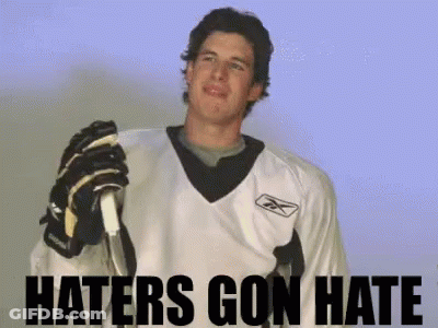 A Hockey Player Is Holding A Stick With The Words Haters Gon Hate Behind Him GIF
