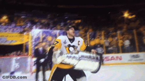 A Hockey Player Is Holding A Trophy In Front Of A Nissan Sign GIF
