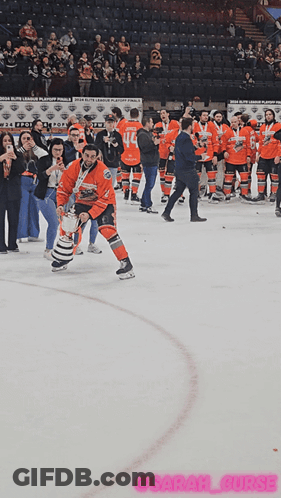 A Hockey Player Is Holding A Trophy On The Ice In Front Of A Crowd GIF