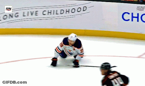 A Hockey Player Is Kneeling On The Ice In Front Of A Sign That Says Long Live Childhood GIF