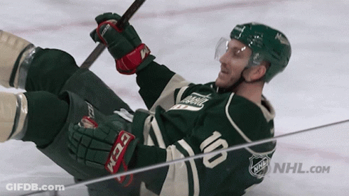 A Hockey Player Is Laying On The Ice With The Number 10 On His Jersey GIF