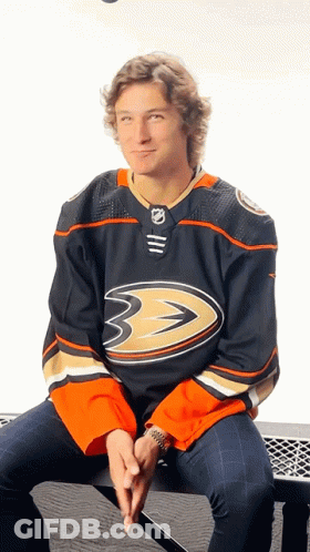 A Hockey Player Is Sitting On A Bench Wearing A Black Jersey With The Number 3 On It GIF