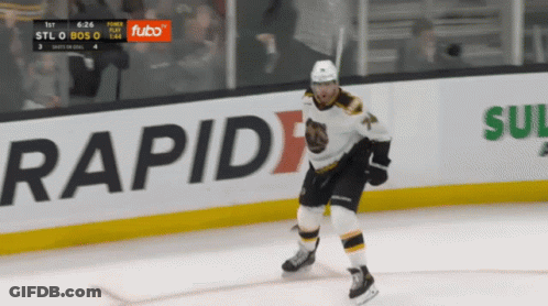 A Hockey Player Is Skating On The Ice In Front Of An Ad For Futbo GIF