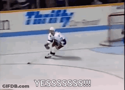 A Hockey Player Is Skating On The Ice With A Puck In His Hands . GIF