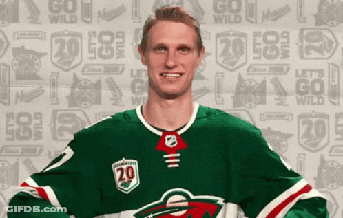 A Hockey Player Is Wearing A Green Jersey With The Number 20 On It GIF