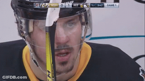 A Hockey Player Is Wearing A Helmet And Holding A Hockey Stick GIF