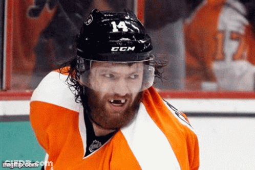 A Hockey Player Is Wearing A Helmet With The Number 14 On It . GIF