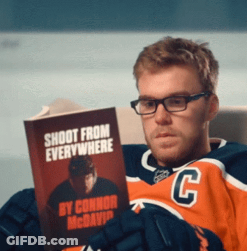 A Hockey Player Reading A Book Called Shoot From Everywhere GIF