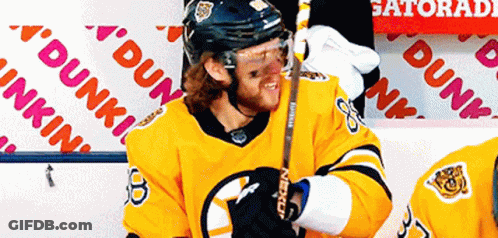 A Hockey Player Stands In Front Of A Dunkin ' Donuts Sign GIF