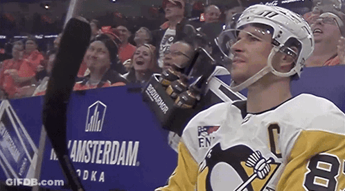A Hockey Player Stands In Front Of A Sign That Says Amsterdam GIF