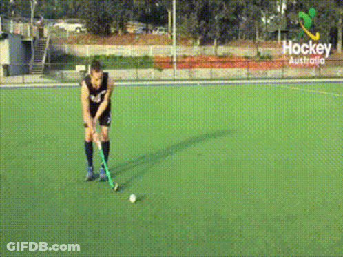A Hockey Player Stands On A Field With A Sign That Says Hockey Australia GIF