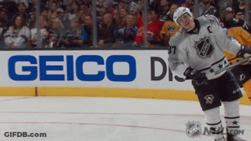 A Hockey Player Stands On The Ice In Front Of A Sign For Geico GIF