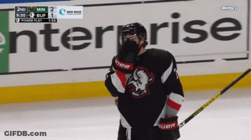 A Hockey Player Stands On The Ice In Front Of An Enterprise Banner GIF