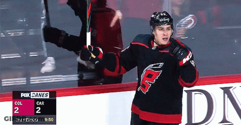 A Hockey Player Stands On The Ice With A Fox Canes Scoreboard In The Background GIF
